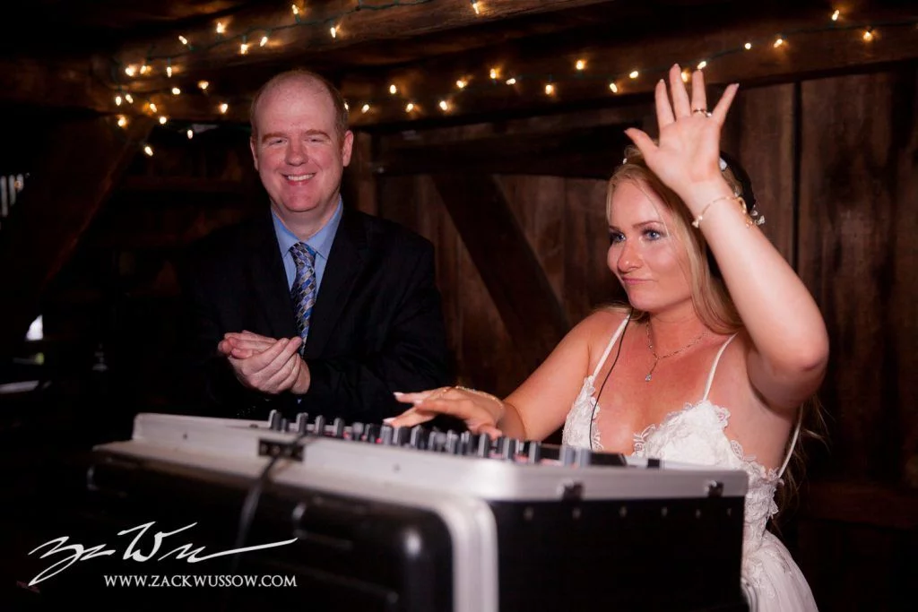 A bride and groom at a wedding with a dj.