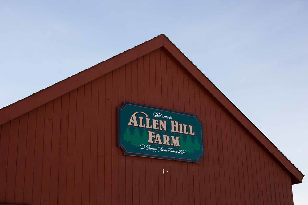 The red barn gable at Allen Hill Farm, a family farm since 1861, stands proudly under a clear sky. Known for its charm and history, it's one of the most picturesque wedding venues in CT.